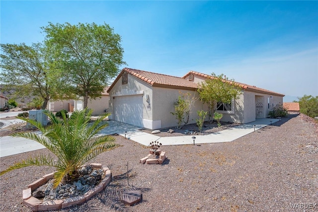 mediterranean / spanish-style home with a tiled roof, an attached garage, and stucco siding