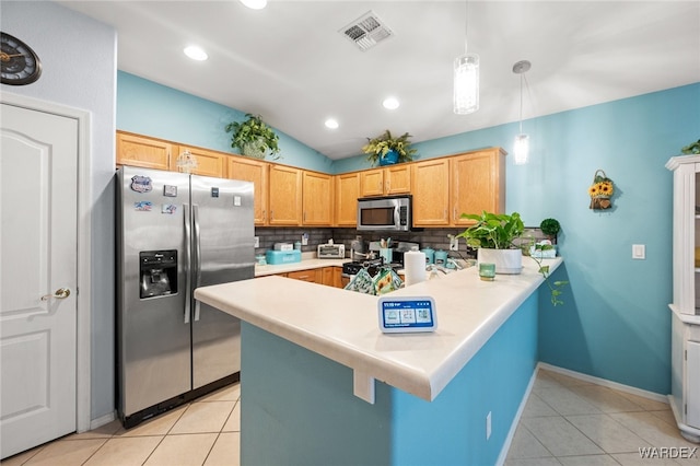 kitchen with a peninsula, visible vents, light countertops, appliances with stainless steel finishes, and decorative light fixtures