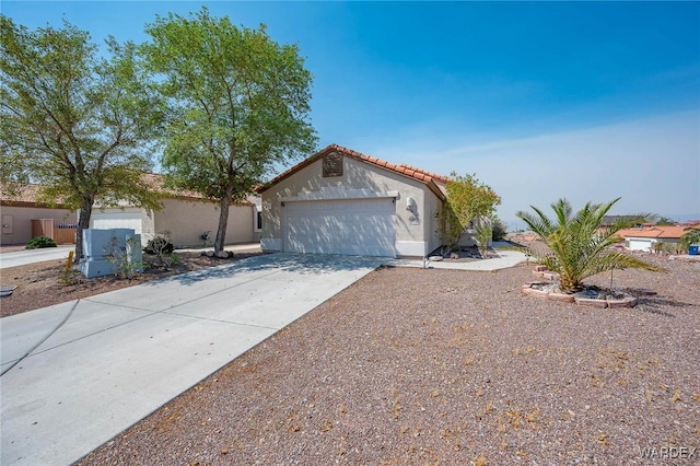 view of front of house with concrete driveway, a tiled roof, an attached garage, and stucco siding