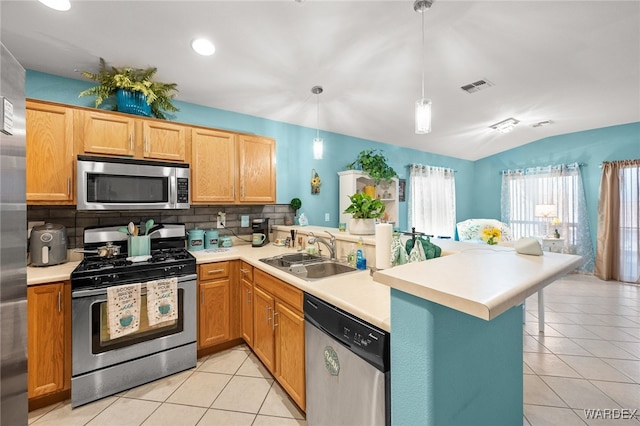 kitchen with visible vents, light countertops, appliances with stainless steel finishes, a sink, and a peninsula