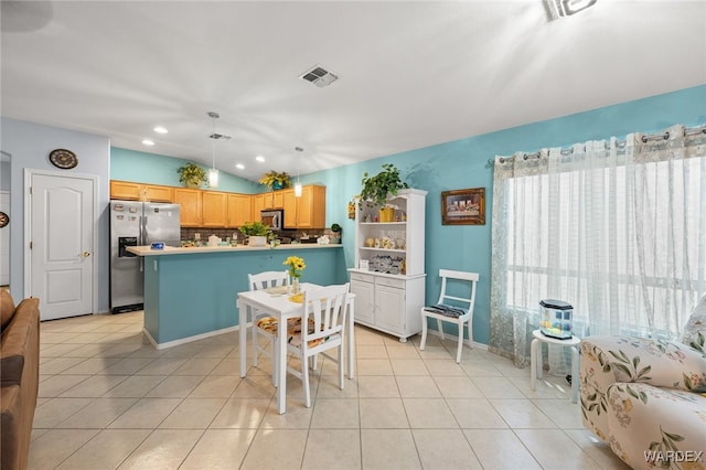 kitchen with appliances with stainless steel finishes, lofted ceiling, visible vents, and light tile patterned floors