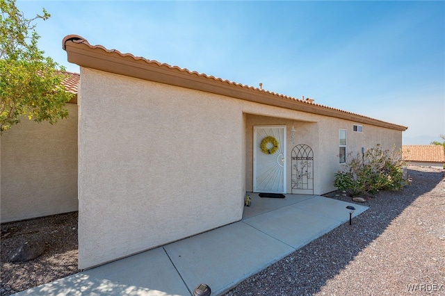 entrance to property with a patio and stucco siding