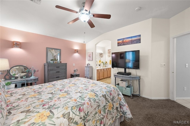 bedroom featuring arched walkways, baseboards, light colored carpet, ceiling fan, and vaulted ceiling