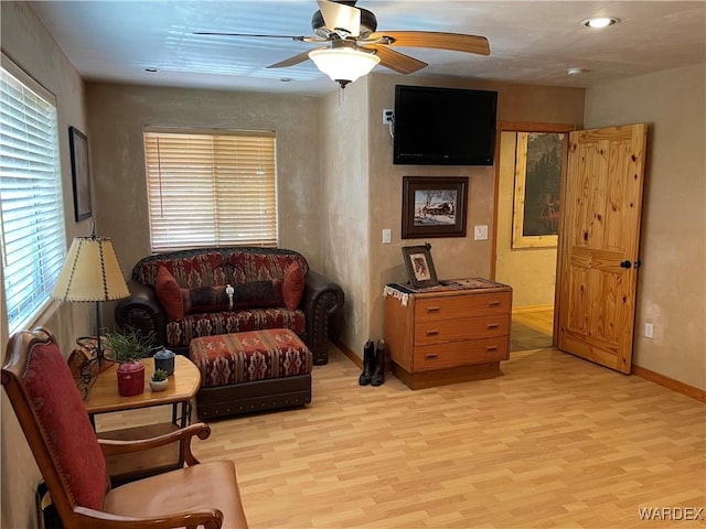 sitting room featuring light wood-type flooring, ceiling fan, and baseboards