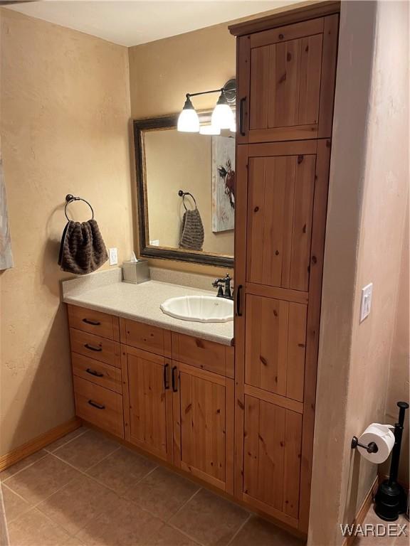 bathroom with tile patterned floors, baseboards, and vanity