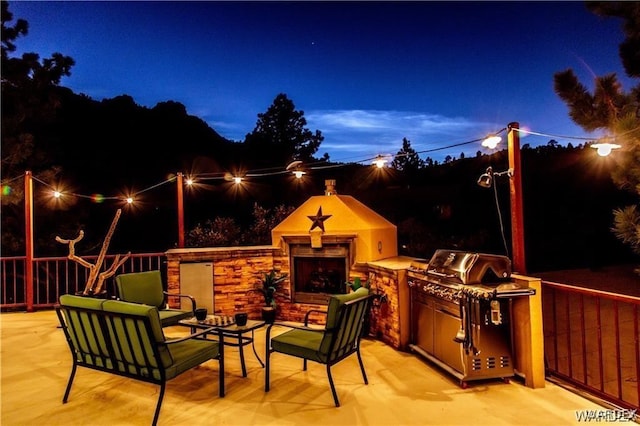 view of patio / terrace featuring a fireplace and an outdoor kitchen