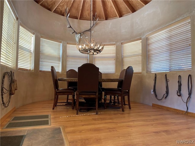 dining space with light wood-type flooring, an inviting chandelier, and visible vents