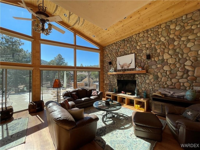 living room featuring high vaulted ceiling, a fireplace, wood finished floors, wood ceiling, and a ceiling fan