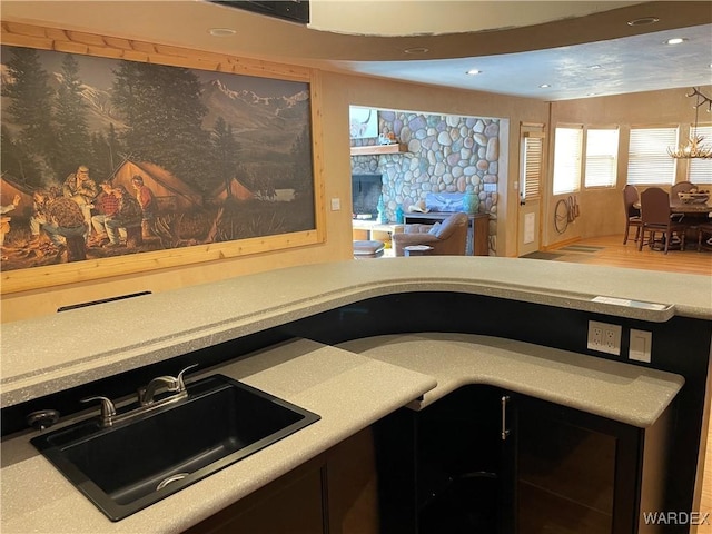 kitchen featuring light countertops, recessed lighting, a sink, and a notable chandelier