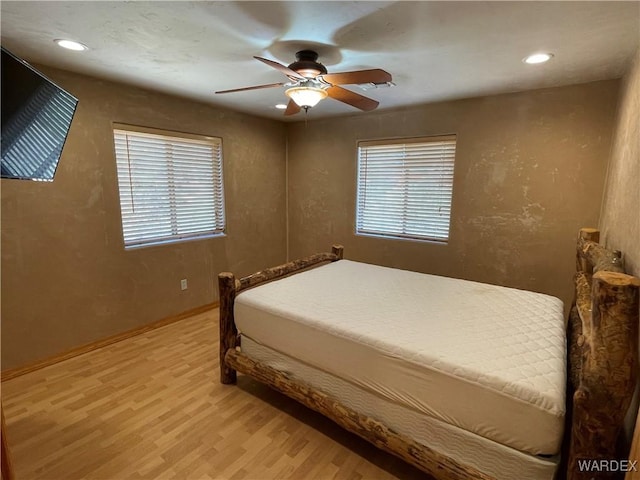 bedroom with multiple windows, light wood-type flooring, a ceiling fan, and recessed lighting