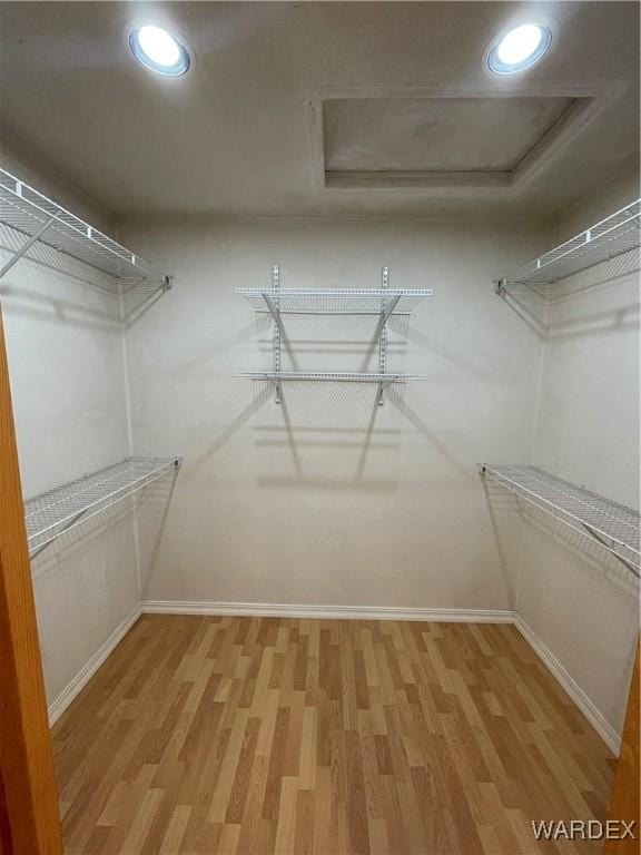 spacious closet featuring attic access and wood finished floors