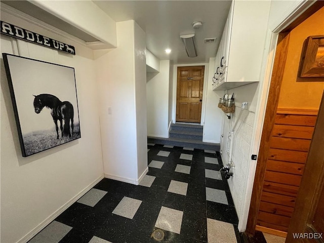 corridor featuring visible vents, dark floors, and baseboards