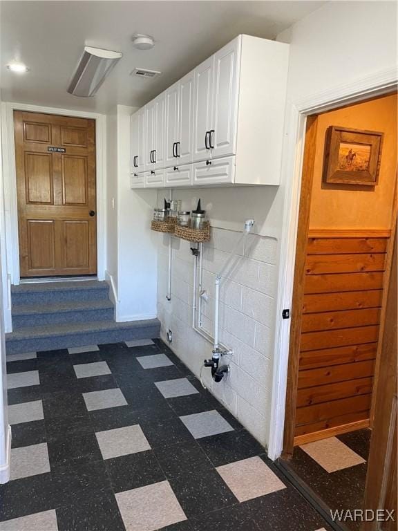 laundry room featuring visible vents, dark floors, and cabinet space