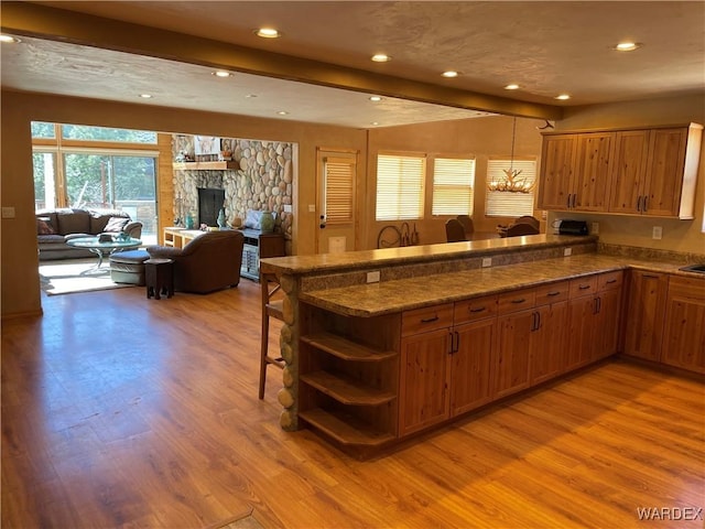 kitchen featuring a peninsula, brown cabinets, and open floor plan