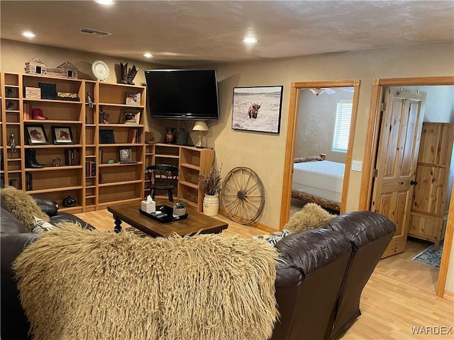 living area featuring light wood-style floors, recessed lighting, and visible vents