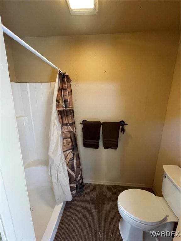 full bath with toilet and a stall shower