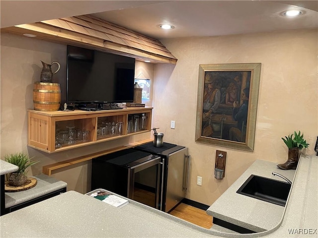 bar featuring recessed lighting, a sink, baseboards, and wood finished floors