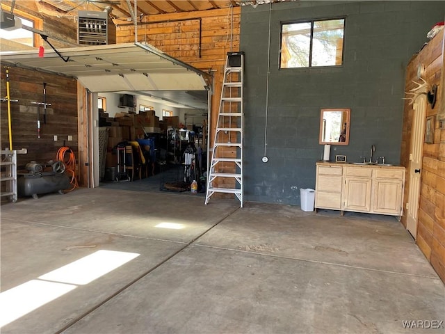 garage featuring concrete block wall, a sink, and a garage door opener