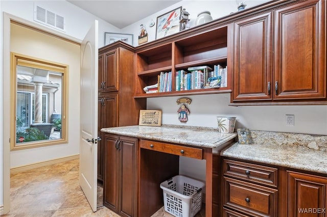 interior space featuring baseboards, visible vents, open shelves, and light stone counters