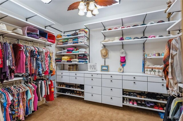 spacious closet with ceiling fan and light colored carpet