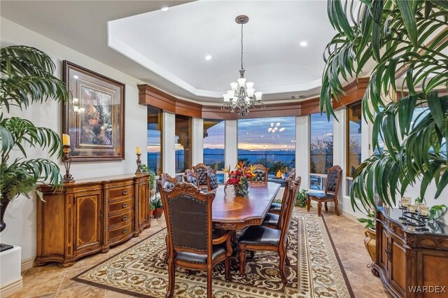 dining area featuring a tray ceiling and a notable chandelier