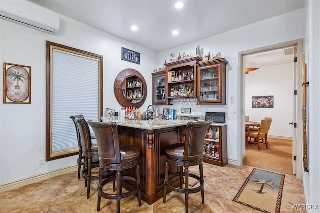 bar with recessed lighting, visible vents, a wall mounted AC, wet bar, and baseboards