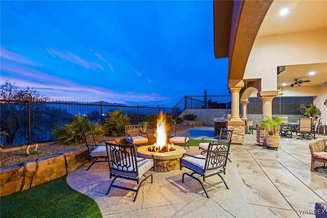 patio terrace at dusk featuring a fire pit