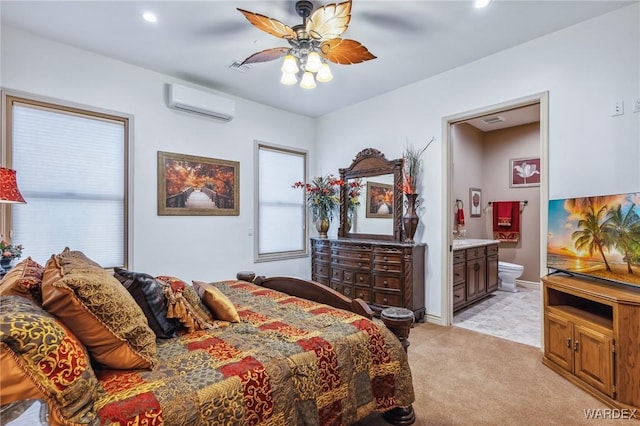 bedroom with recessed lighting, light colored carpet, baseboards, a wall mounted AC, and ensuite bath