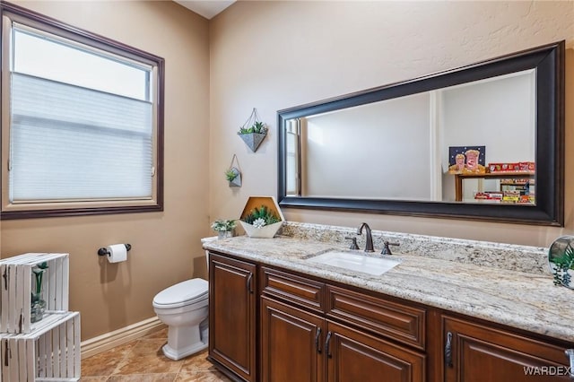 half bathroom with radiator heating unit, baseboards, vanity, and toilet