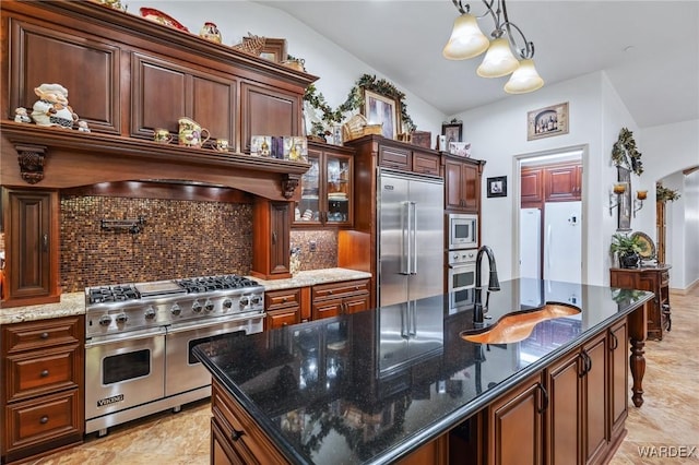 kitchen with built in appliances, a kitchen island, dark stone counters, tasteful backsplash, and glass insert cabinets