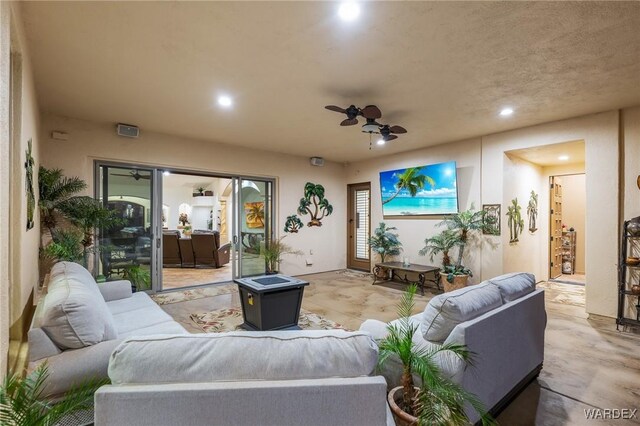 living area with ceiling fan, concrete flooring, and recessed lighting