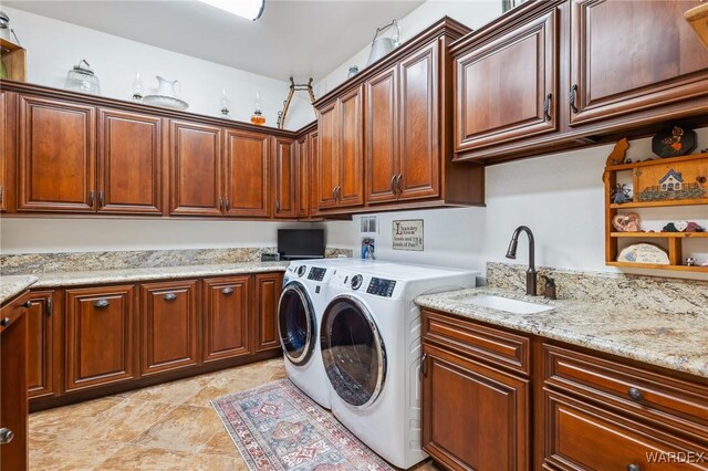 laundry room featuring washing machine and clothes dryer, a sink, and cabinet space