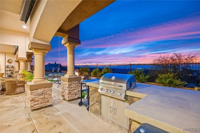 view of patio / terrace with exterior kitchen, fence, and grilling area