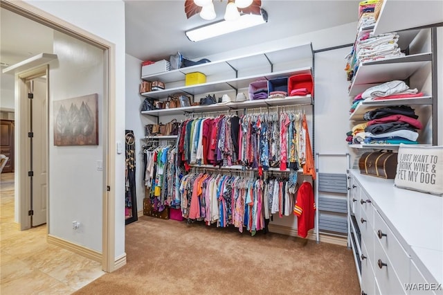 walk in closet with light carpet