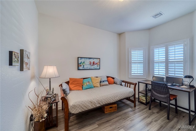 bedroom featuring visible vents and wood finished floors