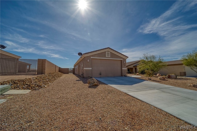 view of front of house featuring concrete driveway, fence, and stucco siding