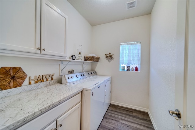 clothes washing area with cabinet space, baseboards, visible vents, independent washer and dryer, and light wood-type flooring