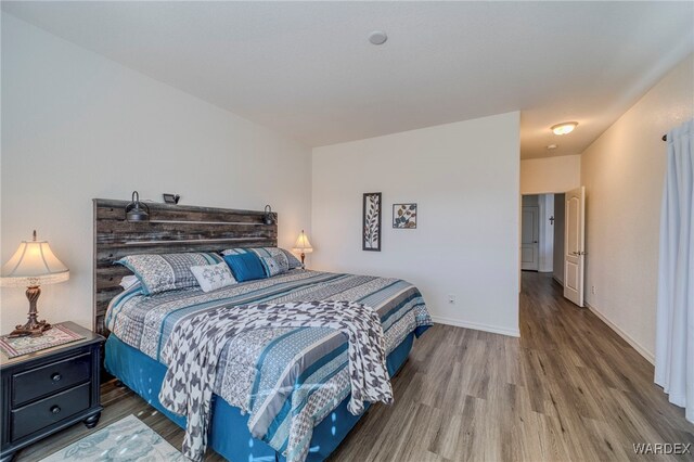 bedroom featuring baseboards and wood finished floors