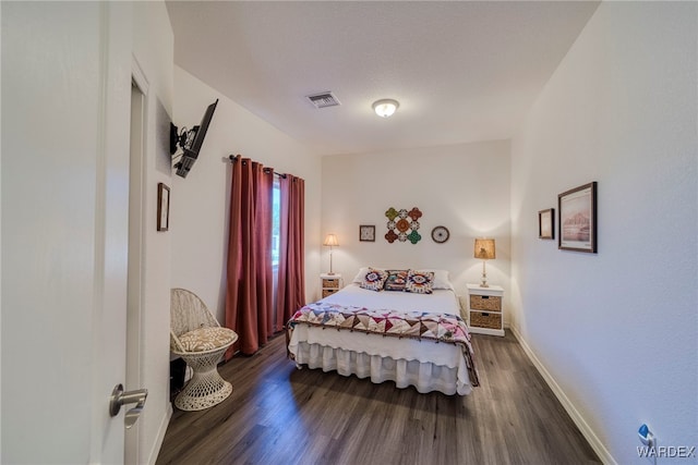 bedroom with baseboards, visible vents, and dark wood-style flooring