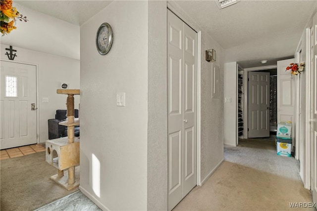 entryway with light carpet and light tile patterned floors