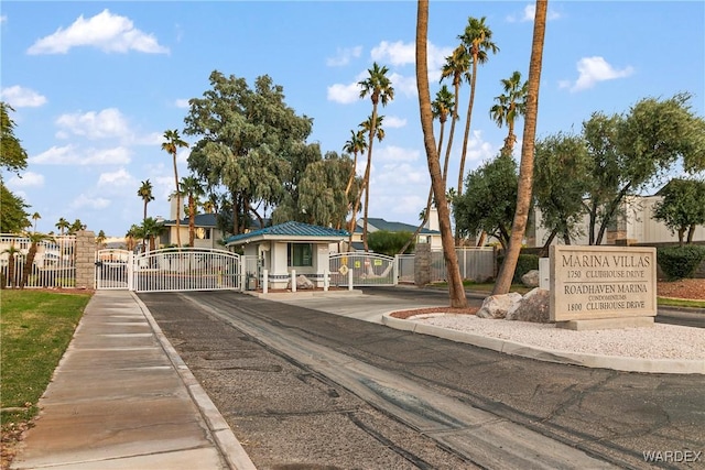 view of street with a gate, curbs, and a gated entry