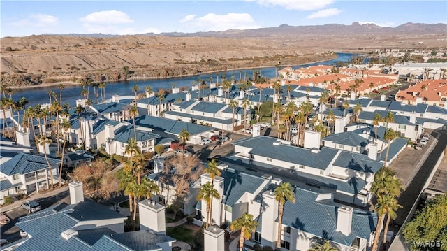 drone / aerial view with a water and mountain view and a residential view