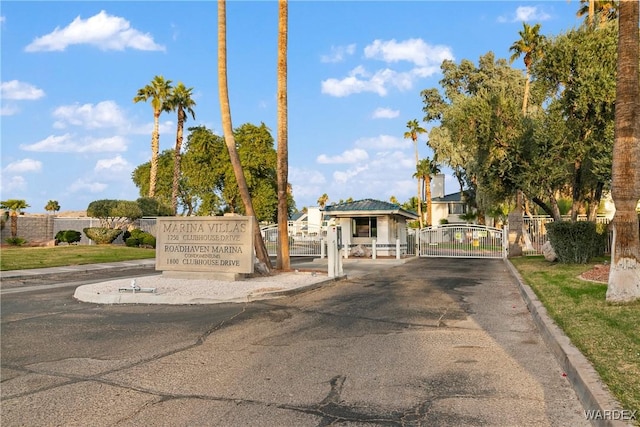 view of street with curbs, a gated entry, and a gate