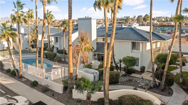 exterior space featuring fence, a residential view, and a community pool