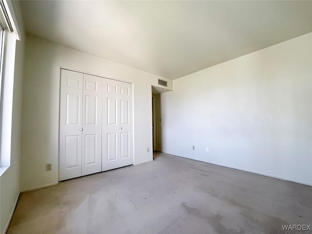 unfurnished bedroom with visible vents and a closet