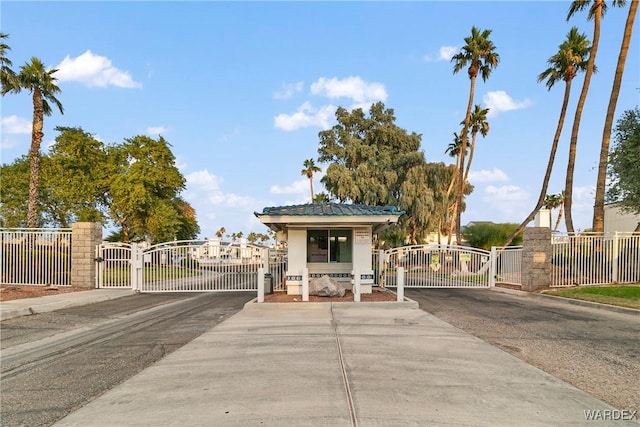 view of front facade featuring driveway, fence, and a gate