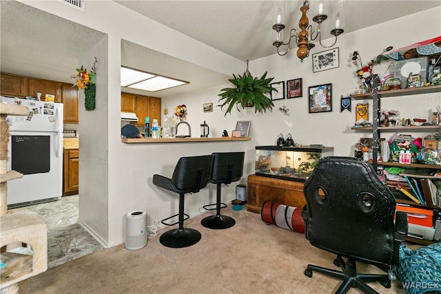 office area with a notable chandelier, baseboards, a sink, and light colored carpet