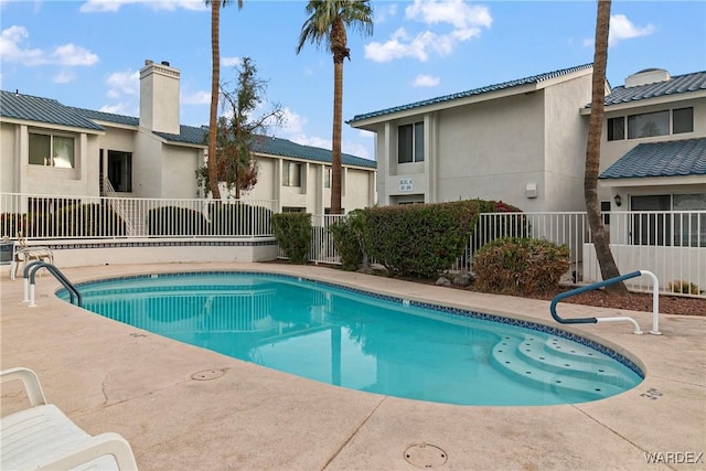 community pool featuring a patio and fence