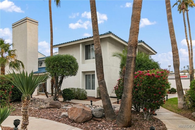 exterior space featuring a chimney and stucco siding