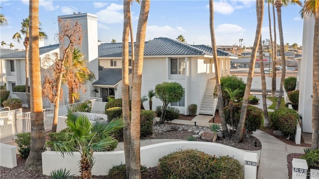 exterior space featuring fence, stairway, and stucco siding